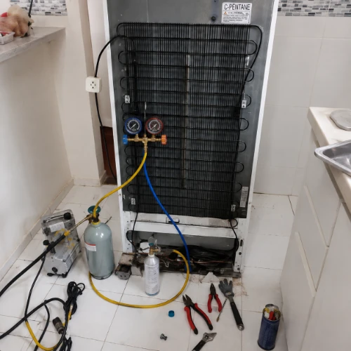 Appliance repair technician doing sealed-system work on a refrigerator in Austin, TX